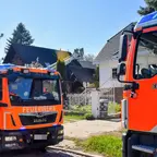Zwei Feuerwehrfahrzeuge der Berliner Feuerwehr vor Wohnhäusern mit ausgefahrener Drehleiter