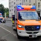 Zwei Einsatzfahrzeuge der Feuerwehr mit Blaulicht stehen auf einer Straße, im Hintergrund liegt ein Motorrad auf der Seite.
