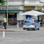 Polizeiwagen mit Blaulicht vor dem Bierhaus Urban an einer Straßenecke, ein Polizist sichert den Bereich mit Absperrband ab.