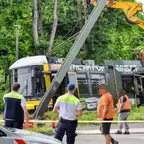 Schiefer Mast nach Kollision mit Straßenbahn, mehrere Personen in Warnkleidung und zwei Mitarbeiter der BVG-Sicherheit sichern die Unfallstelle ab