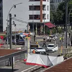 Unfallstelle an einer Kreuzung mit beschädigten Fahrzeugen, Einsatzkräften und Absperrungen bei sonnigem Wetter.