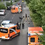 Mehrere Rettungsfahrzeuge und Einsatzkräfte stehen auf einer Straße neben einem auf der Straße liegendem Motorrad