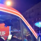 Rotes Einsatzfahrzeug mit Blaulicht vor beleuchtetem U-Bahn-Schild 'U Rathaus Neukölln' und einem Einfahrt-verboten-Schild in einer nächtlichen Straßenszene