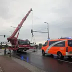 Kranwagen hebt ein Fahrzeug an einer Kreuzung an, daneben steht ein Einsatzleitwagen der Berliner Feuerwehr mit Blaulicht.