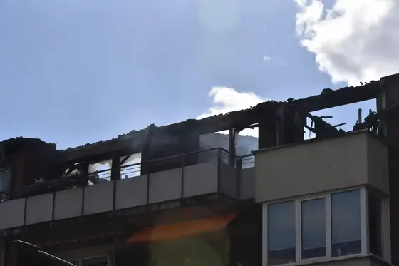 Oberste Etage eines Gebäudes mit stark beschädigtem und verkohltem Dach nach Brandereignis.