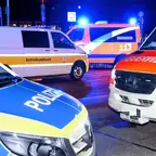 Mehrere Einsatzfahrzeuge von Polizei, Feuerwehr und Betriebsaufsicht stehen nachts mit eingeschalteten Blaulichtern auf einer Straße