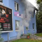 Blaues Wohnhaus mit Rauch, der aus dem Keller dringt.