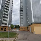 Zwei hohe Wohngebäude mit grauen Fassaden und weißen Balkonen, dazwischen eine abgesperrte Zufahrt mit rot-weißem Absperrband.