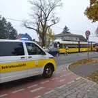 Weißer Transporter mit gelbem Streifen und Aufschrift 'Betriebsaufsicht' steht auf einem Radweg neben einer Straße mit mehreren Fahrzeugen, darunter eine gelbe Straßenbahn und ein Einsatzfahrzeug mit Blaulicht.