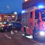 Feuerwehrauto mit Blaulicht auf der Straße, dahinter schwarzer BMW und silberner Hyundai in einem Unfall verwickelt.