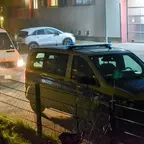 Polizeifahrzeug vor Feuerwehrfahrzeug mit eingeschaltetem Scheinwerfer vor einer Feuerwache.