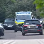 Mehrere geparkte Autos an einer Straße, darunter ein schwarzer Audi und ein Polizeifahrzeug mit blau-gelber Beklebung in der Mitte.