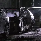 Ein explodiertes Auto zwischen in einer Reihe geparkter PKW.