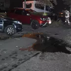 Zwei beschädigte Fahrzeuge an einer Straße bei Nacht, ausgelaufene Betriebsmittel auf dem Asphalt, zwei Feuerwehrleute in Schutzkleidung im Hintergrund.