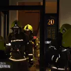 Mehrere Feuerwehrleute in Schutzkleidung und Helmen stehen vor einem Haus mit der Nummer 20.