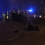 Motorblock liegt auf der Straße, im Hintergrund Einsatzkräfte bei einem verunfallten Fahrzeug mit Blaulicht.