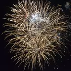 Mehrere goldene Feuerwerkskörper explodieren vor schwarzem Nachthimmel