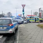 Verkehrsunfall mit einem Polizeiwagen und einem silbernen Mercedes an einer Kreuzung, ein weiterer Polizeiwagen steht im Vordergrund, Ampel zeigt grün