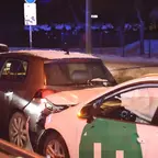 Zwei Autos stehen am Abend auf einer Straße, eines mit beschädigter Front und ausgelösten Airbags, das andere mit beschädigtem Heck.