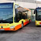 Zwei gelb-orange lackierte Busse der Barminer Busgesellschaft stehen nebeneinander vor einem Gebäude, beide mit der Aufschrift 'Barminer Busgesellschaft' im Zielanzeigefeld.