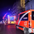 Straße mit mehreren Einsatzfahrzeugen der Berliner Feuerwehr bei Nacht